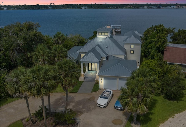 aerial view at dusk featuring a water view