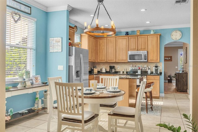 kitchen featuring crown molding, light tile patterned floors, and stainless steel appliances