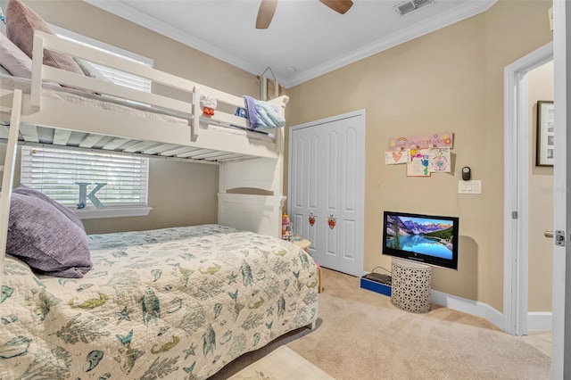 bedroom featuring crown molding, ceiling fan, light colored carpet, and a closet