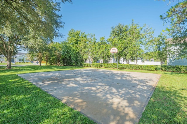 view of sport court with a lawn