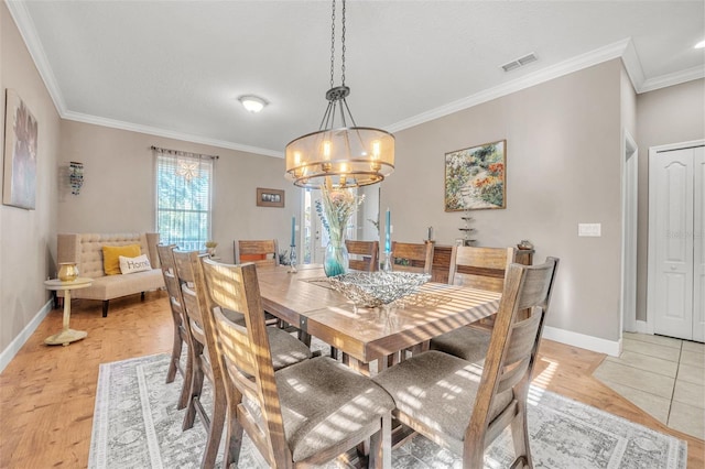 dining space featuring a notable chandelier, light wood-type flooring, and ornamental molding