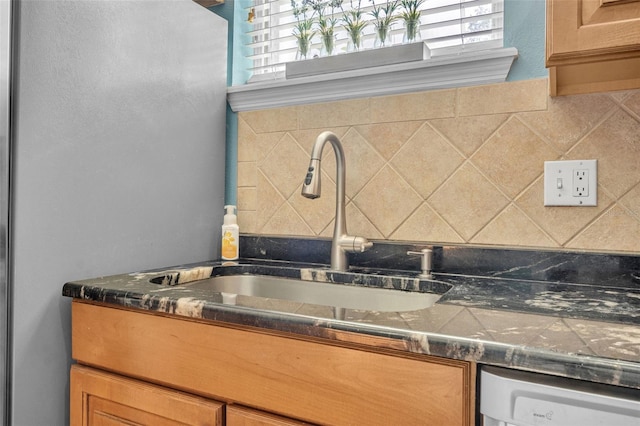 interior space featuring sink, tasteful backsplash, and stainless steel dishwasher