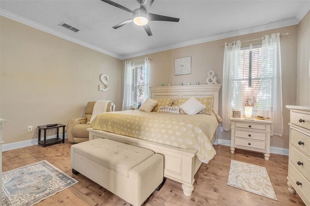 bedroom featuring light hardwood / wood-style flooring, multiple windows, ceiling fan, and crown molding