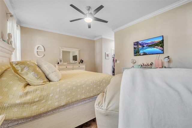 bedroom featuring ceiling fan, a fireplace, crown molding, and wood-type flooring