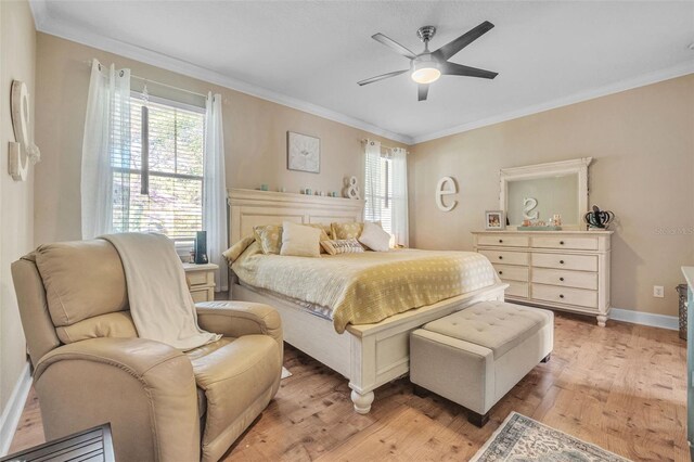 bedroom featuring light wood-type flooring, ornamental molding, and ceiling fan