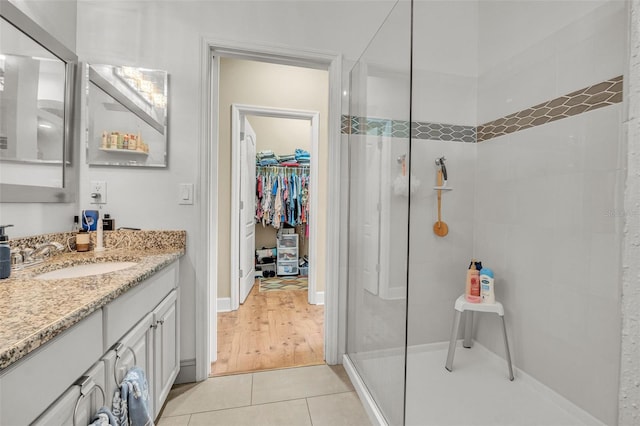 bathroom featuring tiled shower, vanity, and hardwood / wood-style floors