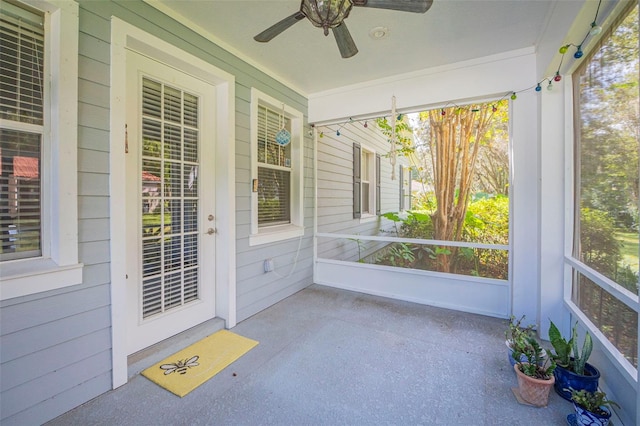 unfurnished sunroom featuring ceiling fan