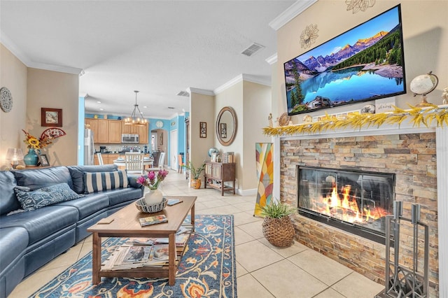 living room with a notable chandelier, a fireplace, ornamental molding, and light tile patterned flooring