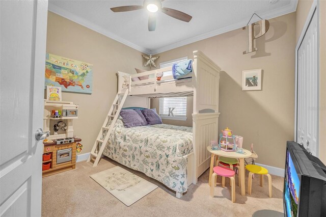 bedroom with ceiling fan, light colored carpet, a closet, and crown molding