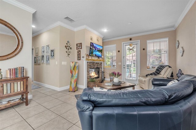 living room featuring a textured ceiling, a fireplace, ornamental molding, and light tile patterned flooring