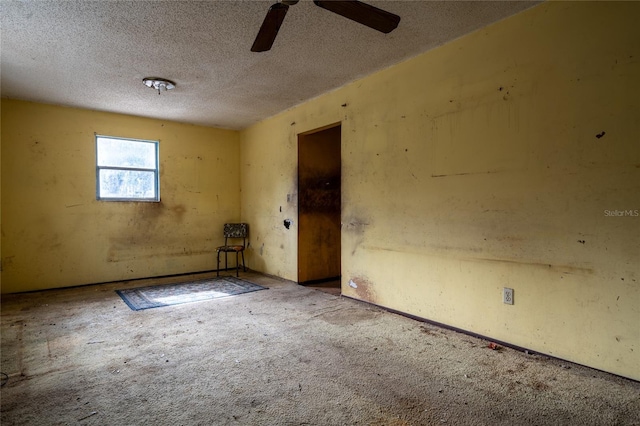 unfurnished room with ceiling fan, a textured ceiling, and carpet flooring