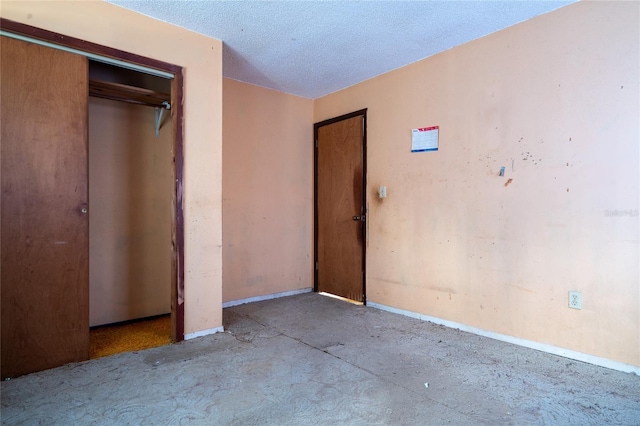 unfurnished bedroom featuring a textured ceiling and a closet