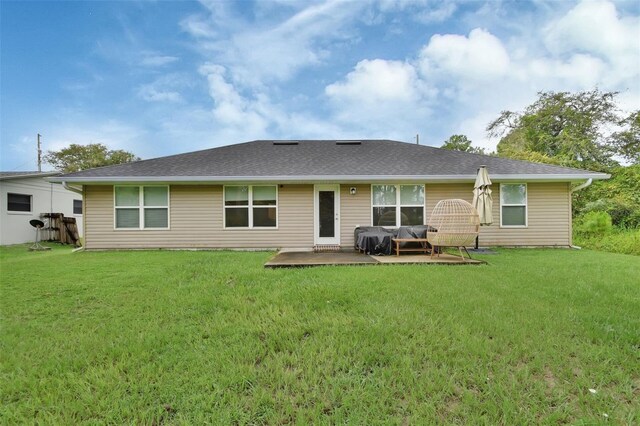 rear view of property featuring a patio and a lawn