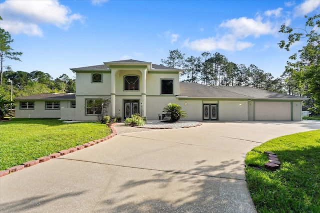 view of front facade with driveway, stucco siding, an attached garage, and a front yard