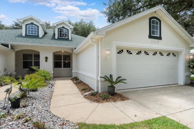 view of front of house featuring stucco siding, concrete driveway, an attached garage, and a shingled roof