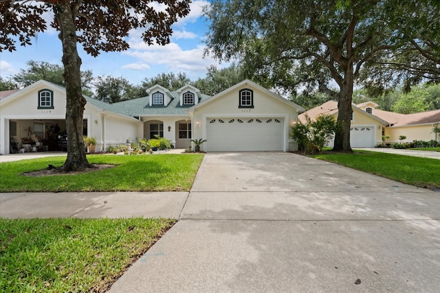 view of front of home featuring stucco siding, an attached garage, concrete driveway, and a front yard