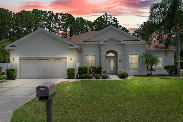 view of front facade with roof with shingles, driveway, stucco siding, a garage, and a lawn