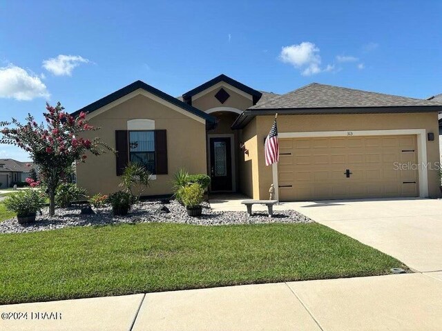 view of front of house featuring a garage and a front lawn