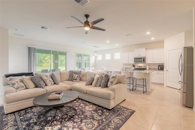 living room with light tile patterned floors and ceiling fan