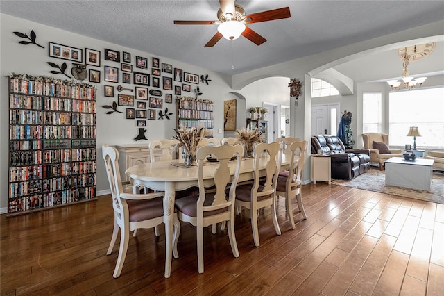 dining area featuring a textured ceiling, hardwood / wood-style floors, and a chandelier