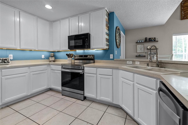 kitchen featuring sink, appliances with stainless steel finishes, a textured ceiling, and white cabinets