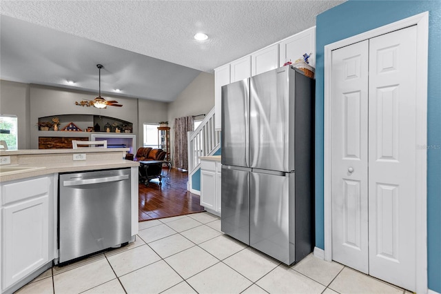 kitchen featuring light hardwood / wood-style floors, appliances with stainless steel finishes, white cabinets, and ceiling fan