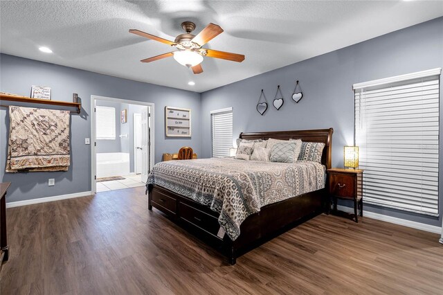 bedroom featuring ensuite bathroom, a textured ceiling, ceiling fan, and hardwood / wood-style floors