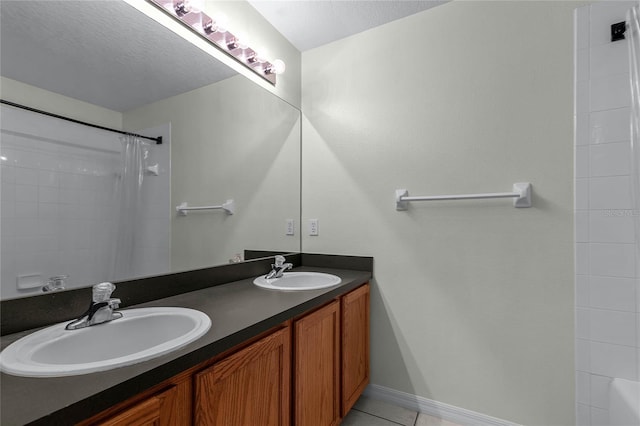 bathroom with double vanity, tile patterned floors, shower / bath combo, and a textured ceiling