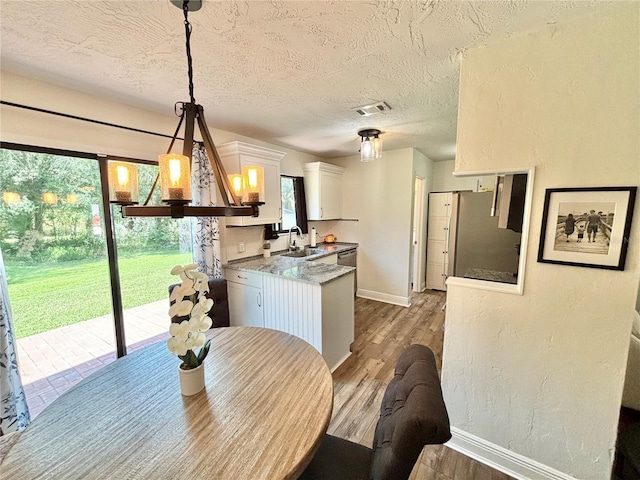 dining area with dark wood-type flooring, sink, and a textured ceiling