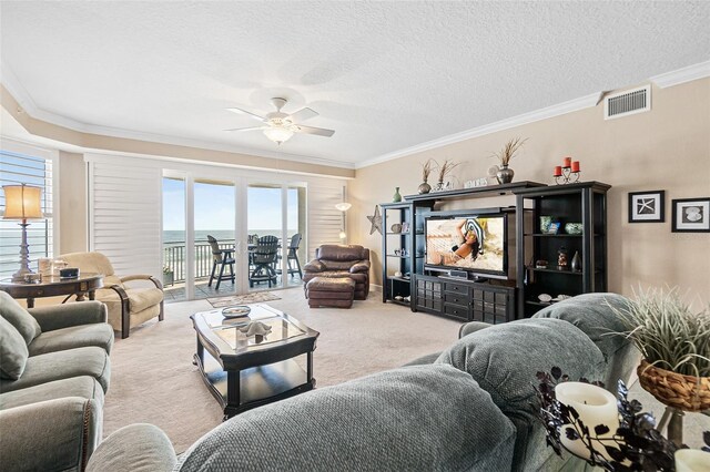 carpeted living room featuring crown molding, a textured ceiling, and ceiling fan