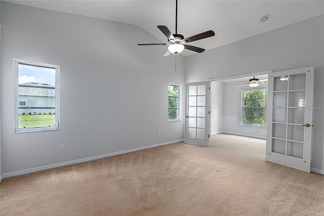 empty room with light carpet, high vaulted ceiling, ceiling fan, and french doors