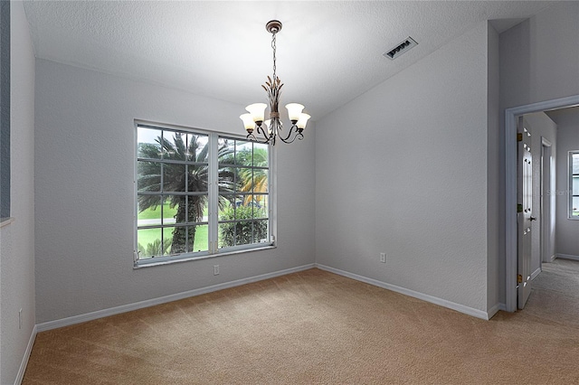 carpeted empty room featuring plenty of natural light, a chandelier, and vaulted ceiling