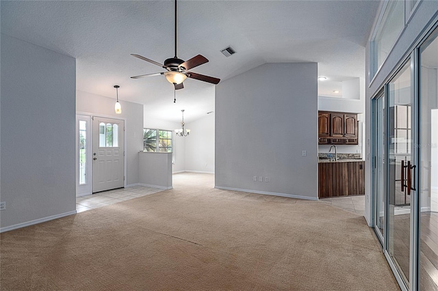 unfurnished living room featuring lofted ceiling, light colored carpet, and ceiling fan with notable chandelier