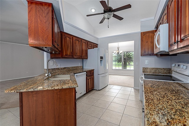 kitchen featuring white appliances, ceiling fan with notable chandelier, light carpet, vaulted ceiling, and sink