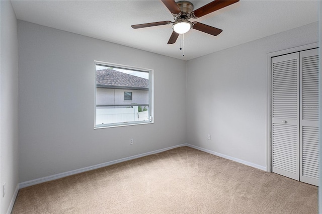 unfurnished bedroom featuring a closet, carpet flooring, and ceiling fan