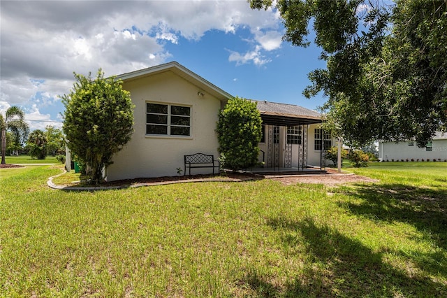 back of house with a lawn and a patio area