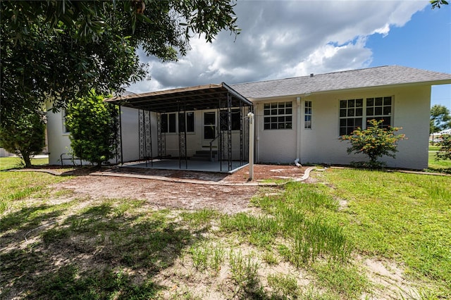 back of property featuring a patio and a lawn