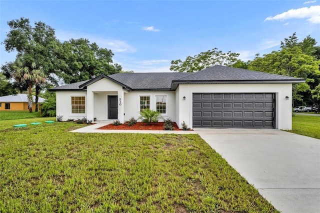 view of front of home with a garage and a front lawn