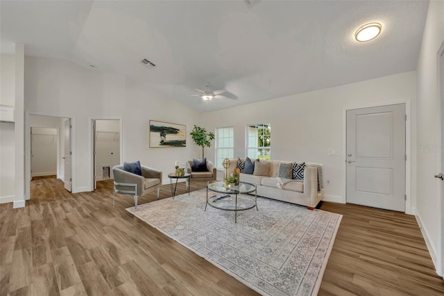 living room featuring ceiling fan, light hardwood / wood-style flooring, and high vaulted ceiling