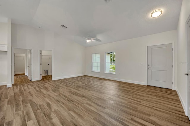 unfurnished living room featuring vaulted ceiling, ceiling fan, light hardwood / wood-style floors, and a textured ceiling