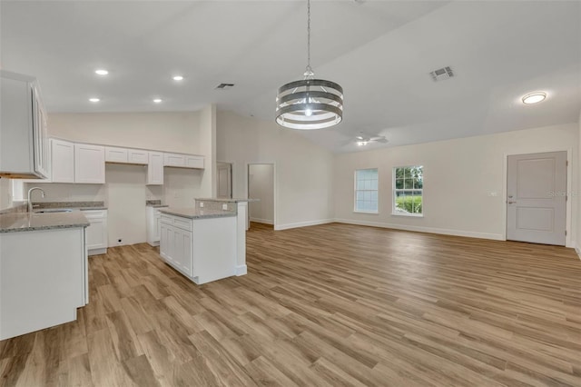 kitchen featuring light hardwood / wood-style floors, sink, white cabinets, and high vaulted ceiling