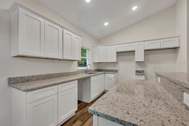 kitchen with dark hardwood / wood-style flooring, white cabinets, sink, light stone countertops, and vaulted ceiling