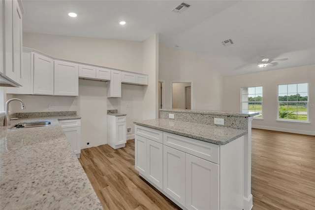 kitchen with sink, white cabinetry, ceiling fan, and light wood-type flooring