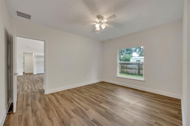 empty room with light hardwood / wood-style floors and ceiling fan