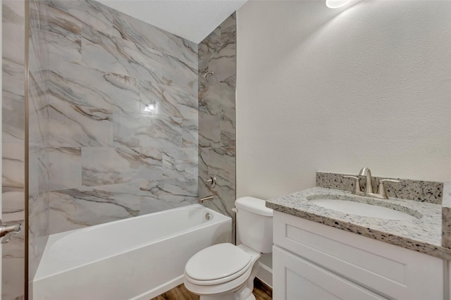 full bathroom featuring hardwood / wood-style floors, tiled shower / bath combo, toilet, and vanity