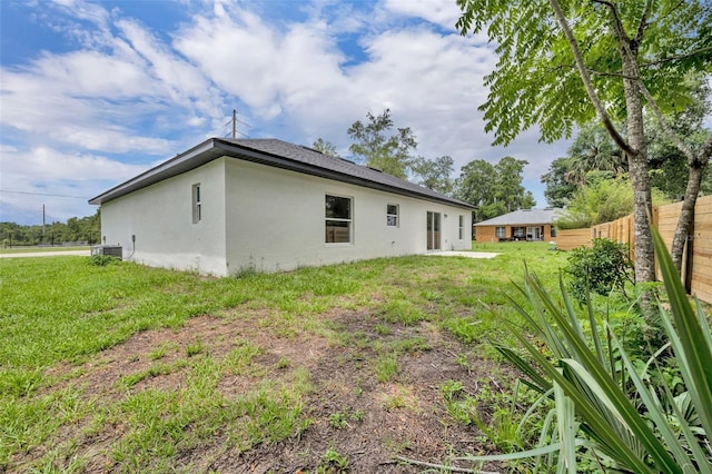210 E Baxter St, De Leon Springs, FL 32130 - rear view of house with stucco siding and central AC unit