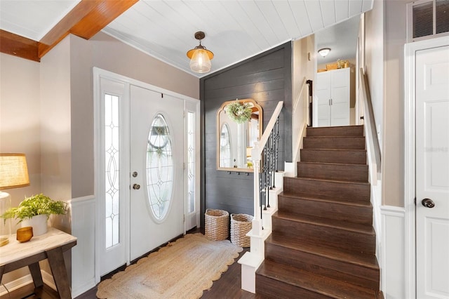 entryway featuring ornamental molding, hardwood / wood-style floors, and beam ceiling