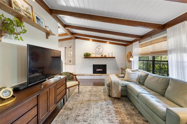 living room with hardwood / wood-style flooring, vaulted ceiling with beams, a brick fireplace, and brick wall