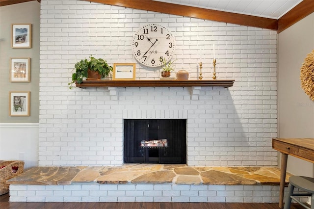 details featuring beamed ceiling, a fireplace, and hardwood / wood-style floors