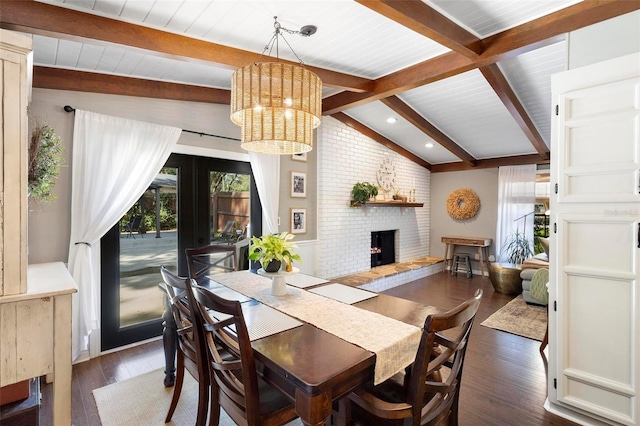 dining space with french doors, a chandelier, dark hardwood / wood-style floors, a fireplace, and lofted ceiling with beams